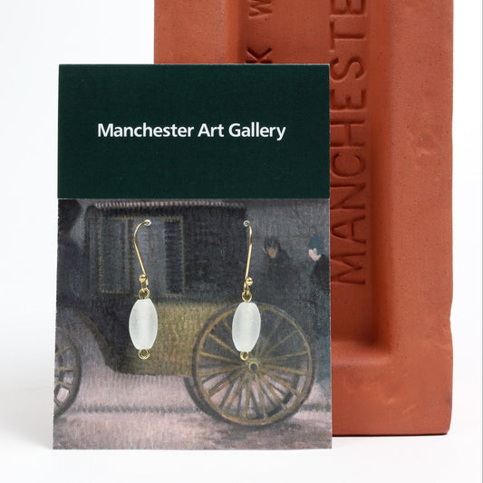 White beaded earrings on a Manchester Art Gallery card with a red brick background.