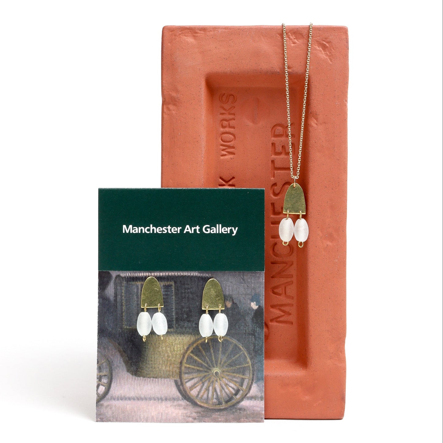 Jewelry set with 'Manchester Art Gallery' card on a white background