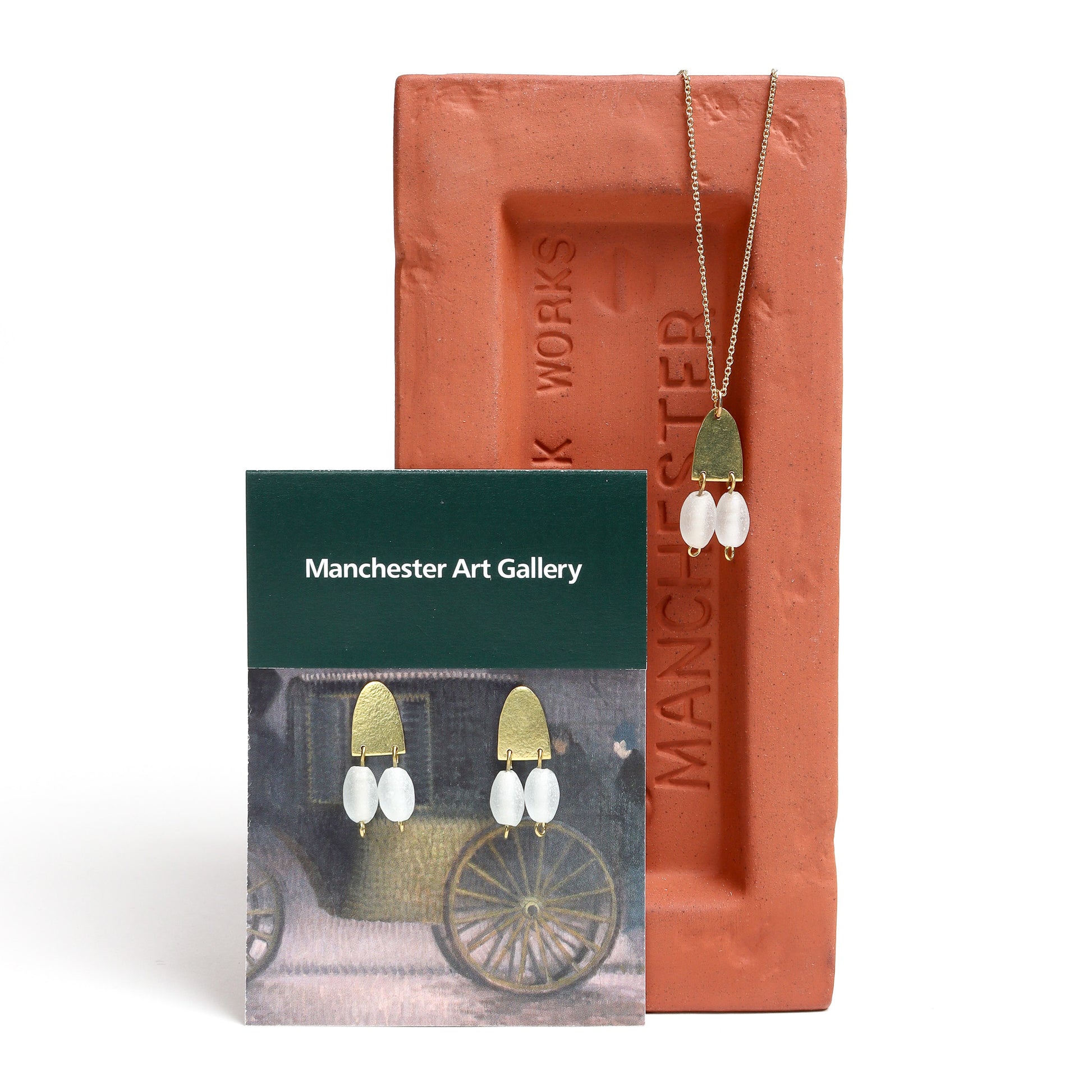 Necklace with pendant on a Manchester Art Gallery card and a terracotta-colored box.