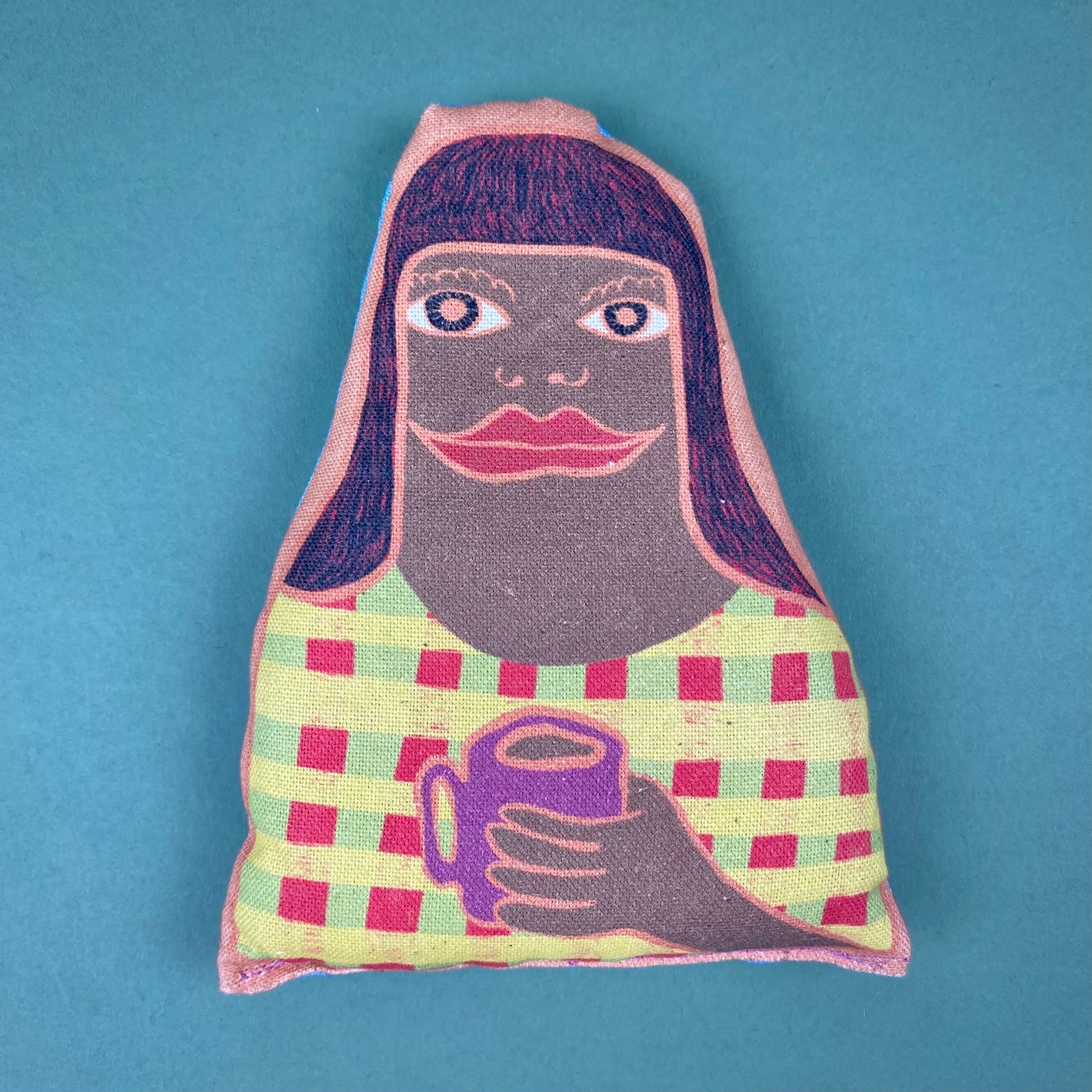 fabric lavender bags with illustrated faces of a woman with long hair holding a mug