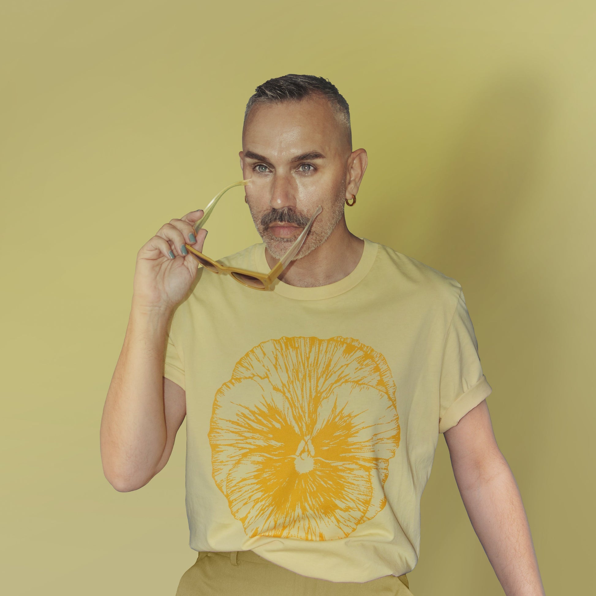 Person wearing a yellow t-shirt with a Pansy design on a matching yellow background