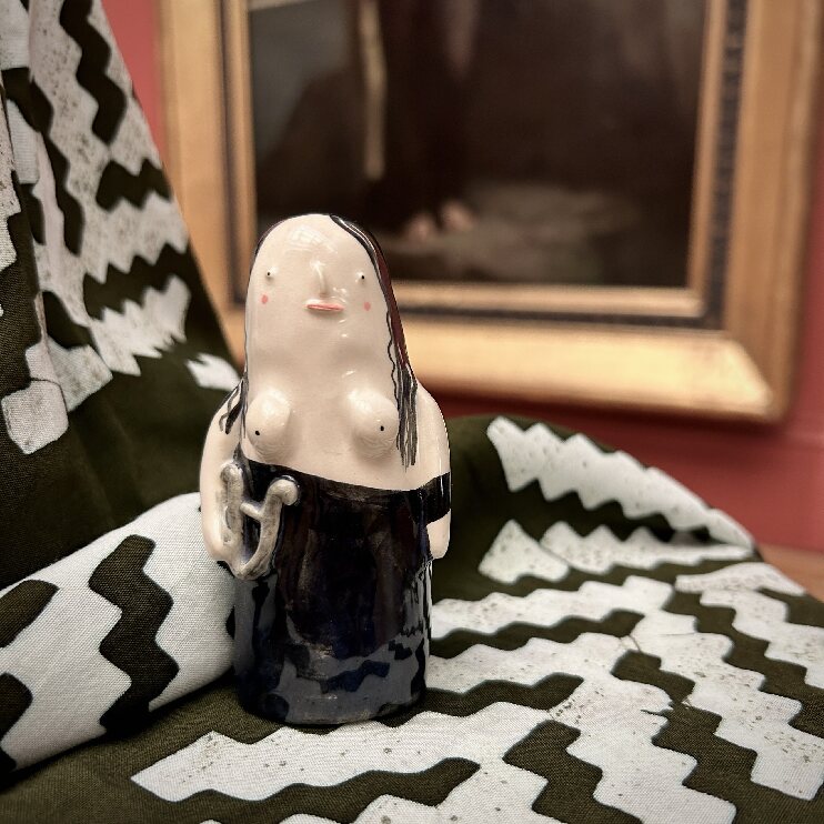 Alex Sickling ceramic figurine set in front of the Sappho Painting in the gallery